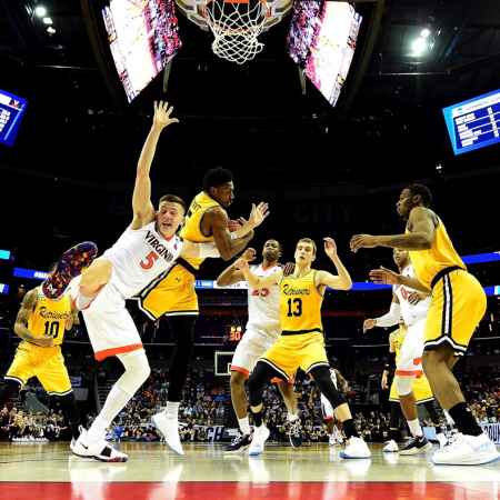 CHARLOTTE, NC - MARCH 16: Jourdan Grant #5 of the UMBC Retrievers competes for the ball against Kyle Guy #5 of the Virginia Cavaliers during the first round of the 2018 NCAA Men's Basketball Tournament at Spectrum Center on March 16, 2018 in Charlotte, North Carolina. (Photo by Streeter Lecka/Getty Images)