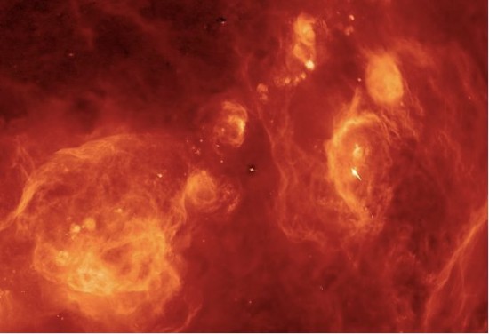 Leuchtendes Gas am Winterhimmel. Barnards Loop im Orion ist der gelbe Halbkreis rechts der Bildmitte. Die Strukturen rechts davon gehören zur Orion-Eridanus-Superblase. Das Band der Milchstraße verläuft von links unten schräg nach oben. Die große Wolke in der linken unteren Ecke sind die Reste der Vela-Supernova, ein Stern, der vor 1000 Jahren explodierte. Procyon ist am oberen Bildrand als winziger Fleck erkennbar. Sirius ist im Zentrum des Bildes.