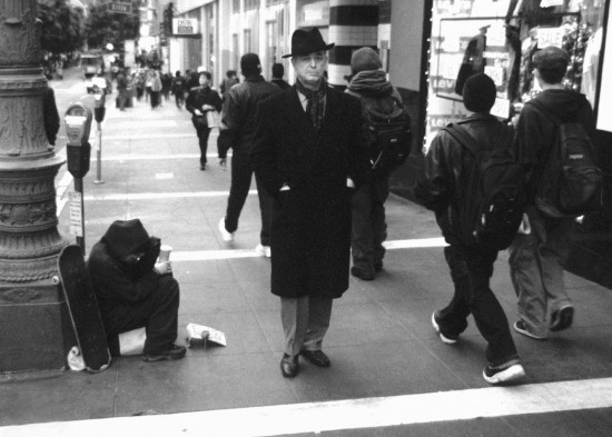 SHIPS THAT PASS in the broad daylight. Mr. Invisible (at left: crouched, shivering, gloveless) shakes his beggar’s cup on a street near headquarters of the United Nations as Mr. Indifferent (center, in natty fedora) warms his hands in cashmere and steps lively past the tired, the poor, the huddled masses, the wretched refuse, et cetera
