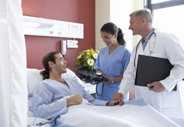 Patient im Bett mit Krankenschwester und Arzt