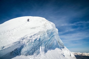 A climber ascending the snow-covered peak of the Bishorn