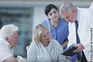 Arzt redet mit sitzenden Patienten