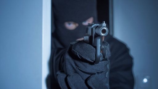 Einbrecher mit Waffe, Symbolbild