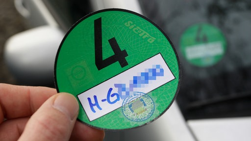 Eine Klimaplakette wird an ein Auto angebracht