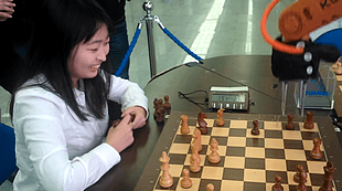 Jeden Zug des Greifarmes mit einem Lächeln quittiert und dann doch verloren: Ju Wenjun an einer Rahmenveranstaltung der WM 2015 in Sochi bei einer Blitzpartie gegen den Roboter