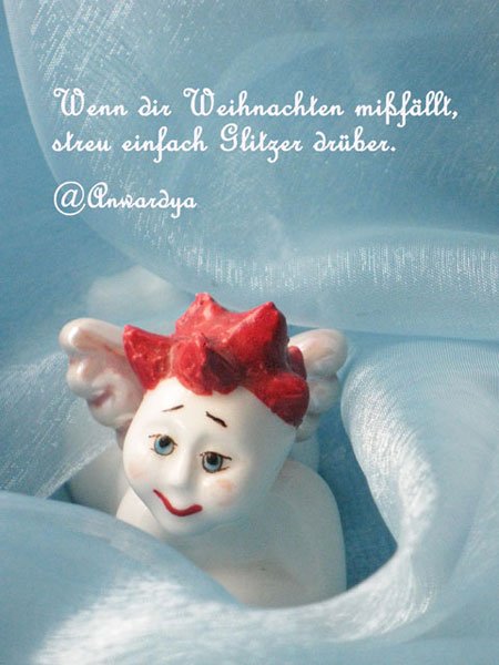 Weißes Porzellanengerl mir roten Haaren auf blauem Hintergrund und einem weihnachtlichen Tweet