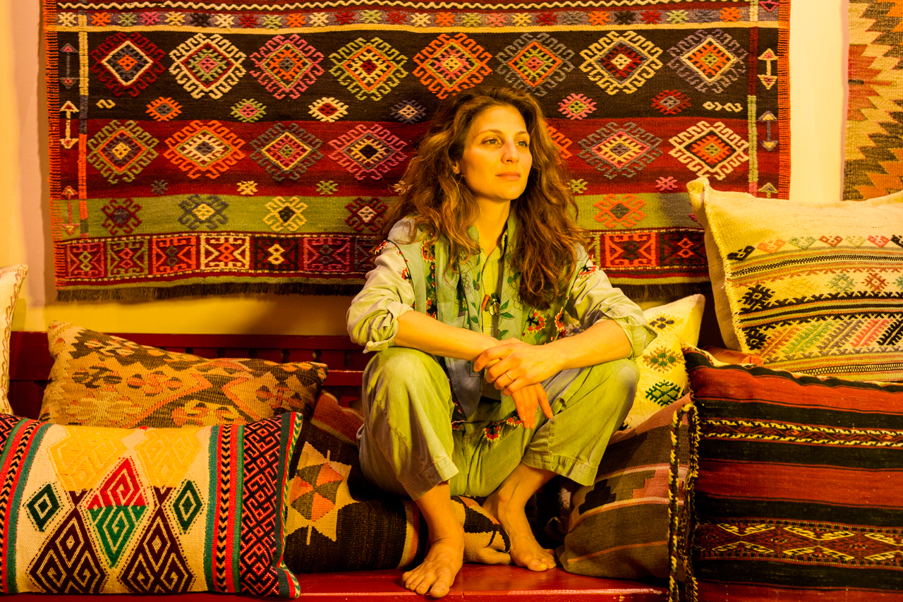 Beyza Nur Özler in ihrem Laden im Kollwitzkiez, umgeben von Kilims
