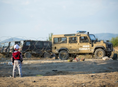 Bub steht vor Stacheldraht und verlassenem Militärfahrzeug, © by Amnesty International/Richard Burton