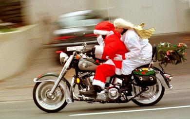 Weihnachtsmann mit Begleitung Der eilige heilige St. Nikolaus mit Engel donnert bereits am Samstag, 4. Dezember 1999, auf seinem schweren Motorrad mit erfreulich leichter Begleitung durch Zürich, damit kein Kind leer ausgeht. (Foto: Keystone/Walter Bieri)