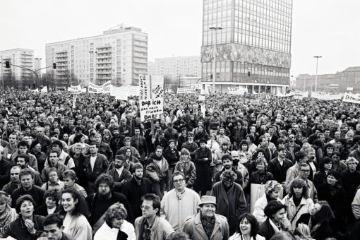 Ostberlin, Alexanderplatz 4. November 1989: Auf dem Ostberliner Alexanderplatz findet die grösste bewilligte Protestdemonstration in der Geschichte der DDR statt. Hunderttausende Manifestanten fordern freie Wahlen, offene Grenzen, Meinungs- und Pressefreiheit und die Abschaffung der Privilegien der SED-Führung. Die Massendemonstration wird vom DDR-Fernsehen live übertragen. Die Mitarbeiter des Fernsehens hatten die Übertragung organisiert, ohne die DDR-Führung davon zu informieren. Diese muss am Fernsehen zuschauen, wie ihr die Macht entgleitet.