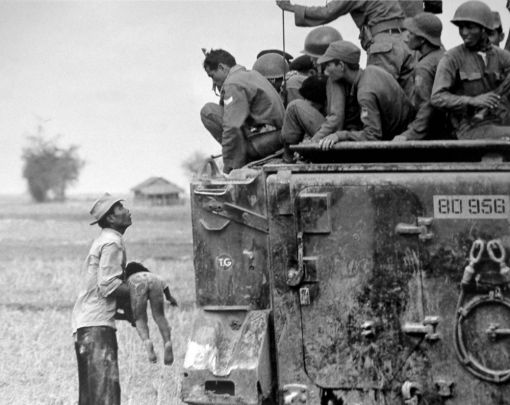 Vietnam, 1964 19. März 1964: Ein Vater zeigt amerikanischen Soldaten vorwurfsvoll seinen Sohn, der bei einem US-Angriff ums Leben kam. (Foto: AP/Horst Faas)