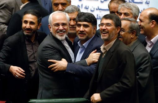 Iran, Ende der Sanktionen Der iranische Aussenminister Mohammad Javad Zarif (vorne links) wird im Parlament von Abgeordneten beglückwünscht. Zuvor hatte der Westen die Sanktionen gegen Iran aufgehoben. Laut der Internationalen Atomenergiebehörde IAEA hat Iran sein Atomprogramm massiv zurückgefahren und damit die wichtigsten Verpflichtungen erfüllt. Iran, die fünf Uno-Vetomächte und Deutschland hatten nach jahrelangen Verhandlungen ein Abkommen geschlossen. Dieses erlaubt Iran die zivile Nutzung der Atomtechnologie, soll aber sicherstellen, dass das Land keine Atomwaffen baut. Nach Angaben der IAEA hat die Islamische Republik die Zahl der Zentrifugen auf 6000 reduziert und die Bestände an angereichertem Uran stark verringert. (Foto: Keystone/EPA/Abedin Taherkenareh)
