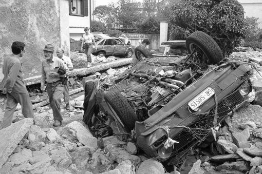 Poschiavo 19. Juli 1987: Heftige Gewitter und Regenfälle verursachen im bündnerischen Puschlav und in der Surselva grosse Schäden. Zahlreiche Flüsse und Bäche treten über die Ufer und hinterlassen ein Bild der Verwüstung. In Poschiavo (Bild) werden Autos und Häuser von Geröllmassen weggeschwemmt. Betroffen ist nicht nur der Kanton Graubünden, sondern vor allem auch das Veltlin. In der zweiten Julihälfte 1987 regnet es fast ununterbrochen. Am 28. Juli rutschen im Veltlin fast 50 Millionen Kubikmeter Fels und Stein ins Tal. Das Dorf Morignone wird völlig zerstört, 53 Menschen sterben. (Foto: Keystone/Arno Balzarini)