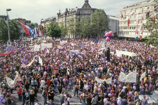 Frauenstreik, Zürich 14. Juni 1991: Frauenstreik in der Schweiz: Im ganzen Land legt eine halbe Millione Frauen die Arbeit für einige Stunden oder den ganzen Tag nieder. Überall finden Kundgebungen statt. Allein auf dem Helvetiaplatz in Zürich (Bild) versammeln sich Tausende. Sie fordern die Umsetzung des vor zehn Jahren in Kraft getretenen Verfassungsartikels über die Gleichstellung von Mann und Frau. Die Frauen kritisieren, dass zehn Jahre nach Inkrafttreten des Gleichstellungsartikels von Gleichstellung, vor allem in finanzieller Hinsicht, noch kaum etwas verwirklicht wurde. Die Organisatorinnen sprechen von einer „friedlichen, aber entschlossenen Kampfstimmung“. (Foto: Keystone/Walter Bieri)