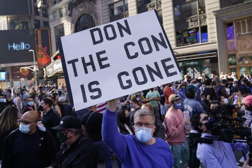 Don the con Feiern auf dem Times Square in New York. Ein Wortspiel: „Don the con is gone. Donald, der Betrüger ist gegangen“. (Foto: Keystone/AP/Seth Wenig)