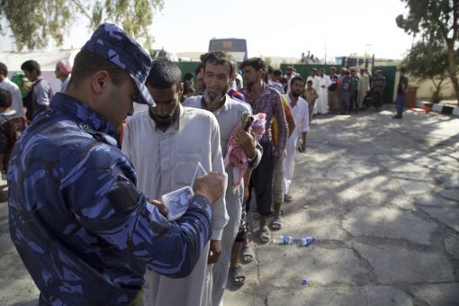 Ein irakischer Polizist kontrolliert eine Gruppe von Zivilpersonen, die sich an einem Sammelpunkt für Geflohene in einem Vorort von Tal Afar eingefunden haben. Die letzte vom IS beherrschte Stadt des Irak soll zu 90 Prozent zurückerobert sein. (Foto: Keystone/AP, Valint Szlanko)
