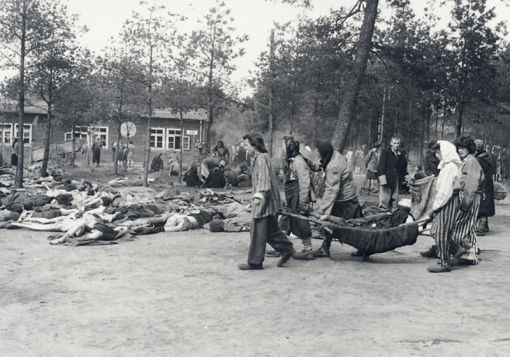 Bergen-Belsen Bergen-Belsen: Häftlinge tragen die Toten aus den Baracken (Foto: PD H. L. Clyn Hughes)