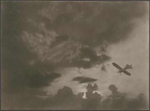 Flugzeug Oskar Teiwes: Flugzeug (Monoplan Blériot XI-2bis) in Wolkenhimmel, Fotograf: Oskar Teiwes, um 1912,, Brömöldruck, Copyright Sammlung Herzog, Schweiz. Nationalmuseum, Inventarnummer LM-112460.46