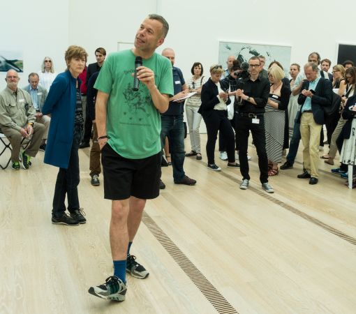 Der Künstler Wolfgang Tillmans erläutert eines seiner Werke, links hinter ihm Theodora Vischer, Senior Curator der Fondation Beyeler, in kuratorischer Fussstellung. Den Hintergrund bilden die Kunstexperten diverser Medien. Foto: Journal21.ch/S.W.