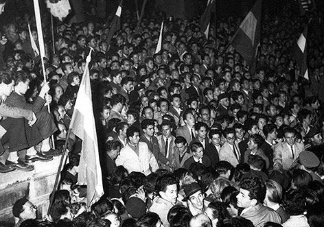 Budapest 1956: Beginn des Aufstandes in Ungarn: Er beginnt mit einer friedlichen Grossdemonstration, zu der Studenten und Studentinnen aufgerufen hatten. 200’000 Menschen versammeln sich am 23. Oktober und protestieren gegen die Regierung und die kommunistische Partei (Bild). Da die Menge in den folgenden Tagen wächst, lässt die Regierung auf die Demonstranten schiessen. Die Einparteien-Diktatur wird durch eine Regierung unter der Leitung von Imre Nagy abgelöst. Am 1. November marschieren fünf Divisionen der Sowjetarmee ein und installieren eine pro-sowjetische Regierung unter János Kádár. Der Aufstand wird niedergeschlagen. 350 Aufständische – unter ihnen Imre Nagy und Pál Maléter – werden hingerichtet. 200’000 Ungarn flüchten ins Ausland, 13’000 in die Schweiz, wo sie mit offenen Armen empfangen werden.