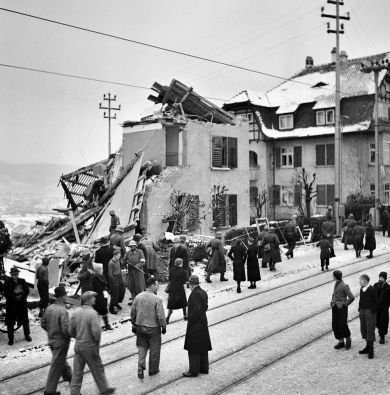 Zürich Ein verirrter britischer Bomber bombardiert irrtümlich Zürich. Fünf Tage nach den Bombenabwürfen auf Basel dringt ein Wellington-Bomber, der den Auftrag hatte, die Mannheimer Motorenwerke zu zerstören, bei schlechtem Wetter in den Schweizer Luftraum ein. Eine erste Sprengladung fällt auf Zürich-Höngg. An der Limmattalstrasse wird ein Wohnhaus zerstört. Ein Frau kommt ums Leben. Weitere Bomben explodieren an der Josefstrasse im Industriequartier neben dem Bahnviadukt. Auch auf dem Viadukt selbst explodierten Sprengsätze. 50 Brandbomben fallen auf die Zahnradfabrik Maag und auf die Werkzeugfabrik Daverio. Im Bild die Limmattalstrasse. (Foto: Keystone/Photopress-Archiv)