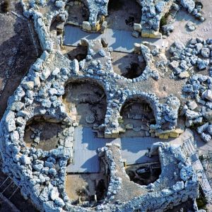 Der Doppeltempel von Ggantija auf der maltesischen Insel Gozo gehört zu den ältesten freistehenden Bauwerken der Menschheit. Das grössere und ältere der beiden Heiligtümer entstand um 3600 v.Chr. – ein Jahrtausend vor der Cheopspyramide.

Die Megalithbauten im maltesischen Archipel – 23 Anlagen unterschiedlicher Erhaltung auf der Hauptinsel Malta und auf Gozo – haben an Prominenz ständig zugelegt. Zunächst stiessen neue Datierungsverfahren die Ansicht um, die in den Megalithen des atlantischen Europa und der westlichen mittelmeerischen Inseln einen Nachhall auf die „grosssen Steine“ in der Ägäis vermutete. Ihnen kommt vielmehr das Erstgeburtsrecht zu, sie sind älter als die minoischen und mykenischen Paläste, viel älter. Und dann wurde auch die Sonderstellung Maltas immer deutlicher. Seine Megalithe sind eine singuläre Schöpfung, die ältesten – erhaltenen –freistehenden Bauwerke der Menschheit.

Emigranten aus Sizilien, Bauern, Fischer, Jäger, besiedelten Malta vor mehr als 7000 Jahren. Um 4000 v. Chr. begannen sie, ihre Toten  in unterirdischen Gräbern beizusetzen – der Anfang eines weitläufigen Systems von Katakomben. Es wird angenommen, dass die Heiligtümer, die sie ab 3600 v. Chr. auf und über dem Boden aus gewaltigen Steinblöcken bauten, unterirdische Grabarchitektur spiegeln. Der Komplex von Ggantija auf Gozo ist beispielhaft: eine wuchtige Aussenmauer, urspünglich an die l6 Meter hoch, legt sich um zwei Kultstätten. Die grössere und ältere, ein Kleeblatt mit zwei nachträglich angefügten Apsiden, entstand um 3600 v. Chr.; der kleinere der Zwilligstempel aus  vier Apsiden und einer Nische ist um einige Jahrhunderte jünger. Blockschutt füllt den Raum zwischen Innentempeln und Aussenmauer. Kraggewölbe überdachten die Tempel, eine künstliche Grotte schaffend.

Elf Jahrhunderte lang scheuten die Tempelbauer alles Kantige und hielten an dem absidialen Grundmuster fest. Sie erweiterten es allmählich zu labyrinthischen Anlagen, die palastähnlichen Charakter annahmen. Aus den anfänglichen Stapeln ungefüger Blöcke wurde 
Mauerwerk aus präzise gefügten Hausteinen. Und Steinmetzen sorgten für mehr und mehr Kunst am Bau: Friese mit Spiralen und, mutmasslich, Opfertieren. Die Ausstattung, Altäre und anderes Mobiliar für Opferrituale, räumt jeden Zweifel an der Deutung der Bauten als „Tempel“ aus. Statuenfunde weisen auf den Kult einer Fruchtbarkeits- und Erdgottheit, der Magna Mater, hin.

So autochthon und isoliert, weder angeregt noch anregend, ihre Kultur war, die Megalithbauer hatten ausgedehnte Handelsbeziehungen. Sie, die resolut in der Steinzeit verharrten, als sich ringsum bereits die Metallverarbeitung durchsetzte, importierten die benötigten Werkzeuge: Steinbeile aus Norditalien, Feuersteinklingen aus Sizilien, Obsidiankeile und –stichel aus Lipari und Pantelleria. Sie verbauten bis zu 57 Tonnen schwere Steine. Was wunder, wenn später die Tempel lange als das Werk von Riesen galten. Im Raumfahrtzeitalter entgingen die geheimnisreichen Kultbauten auch der „Dänikenisierung“ nicht, Ausserirdische sprangen nun für die Riesen ein. Dabei war ja der Transport der grossen Steine auf Steinkugeln und -walzen sowie ihre Aufrichtung mit Hilfe von Erdrampen zwar kein Kinderspiel, aber eine Schufterei, die man so genialen Planern, Organisatoren und Architekten, wie es die Megalithbauer waren, durchaus zutrauen darf.

Maltas Megalithkultur endete jäh um 2500 v.Chr.. Klima- oder Umweltkatastrophe? Hungersnot oder Seuchenzug? Überwältigung der friedfertigen neolithischen Bauern durch bronzezeitliche kriegerische Einwanderer? Darüber werden die Vorgeschichtsforscher noch lange werweissen.

1980 kam lediglich der Ggantija-Komplex von Gozo auf die Liste des Welterbes –- eine unverständliche Rumpf-Auszeichnung, die das Welterbekomitee erst 1992 korrigierte. Nachträglich würdigte es fünf weitere Anlagen auf der Hauptinsel – zwei auf  halbem Weg zu megalithischer Meisterschaft und drei als Beispiele megalithischer Vollendung. – Jahr des Flugbilds: 1996  (Copyright Georg Gerster/Keystone)

