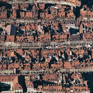 Die Altstadt von Bern
Berns Altstadt kam 1983 auf die Ehrenliste des Welterbes – gleichzeitig mit der Grabmoschee Taj Mahal. Der Zertifizierungsprozess verlief nicht rund. Das australische Mitglied des Komitees, das über die Aufnahme entscheiden sollte, sah anfangs in Bern eine wenig aufregende Kulissenstadt – „just another town, so what’s the fuss“; die Überzeugungsarbeit des Schweizer Botschafters bei der Unesco gewann zuletzt auch die australische Stimme für Bern. Ein afrikanischer Delegierter, ebenfalls Gegner der Kandidatur, wollte wenigstens kein Spielverderber sein und schwänzte zuvorkommend die Sitzung der Abstimmung. Bern kam also nur mit knapper Not auf die Liste. Trotzdem braucht sich in Indien die Welterbestätte Taj Mahal, „eine Träne auf der Wange der Zeit“, der helvetischen Schwester an der Aare nicht zu schämen. Bern vertritt in unübertroffener Reinheit und Reife das urbanistische Muster einer axialen Stadtanlage mit Gassenmarkt. Es gehört zu einer ganzen Stadtfamilie, die die Dynastie der Zähringer rechts und links des Rheins gegründet hatte. Kenner rühmen es als die „geschlossenste und konsequenteste Schöpfung des Städtebaus mindestens im 12. Jahrhundert“ (Paul Hofer). Die Auszeichnung als Welterbe bedeutet immer und in jedem Fall Würde und Bürde, schon gar im Falle einer lebendigen, sich weiter entwickelnden Stadt. Wie die Denkmalpflege Berns – bis 2006 unter Bernhard Furrer – sich ihres Mündels angenommen hat - stets in der Zwickmühle von Bewahrung und Veränderung und stets um das Zusammenspiel von Alt und Neu besorgt - gilt heute international als beispielhaft. Jahr der Aufnahme: 1975. (Copyright Georg Gerster/Keystone)