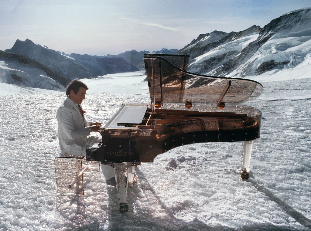 Vor fünf Jahren, am 21. Dezember 2014, stirbt der österreichisch-schweizerische Sänger, Komponist und Pianist Udo Jürgens bei einem Spaziergang in Gottlieben im Kanton Thurgau an Herzversagen. Er wurde 80 Jahre alt. Im Bild: Udo Jürgens spielt auf einem Plexiglas-Piano für eine Fernseh-Produktion auf dem 3454 Meter hohen Jungfraujoch im Jahr 1983. (Foto: Keystone/Stark)

Udo Jürgens gehört zu den kommerziell erfolgreichsten Künstlern im deutschsprachigen Raum. Er verkaufte während seiner fast 60-jährigen Karriere fast hundert Millionen Tonträger. 1966 gewann er mit dem Lied „Merci, Chérie“ den Eurovision Song Contest. 