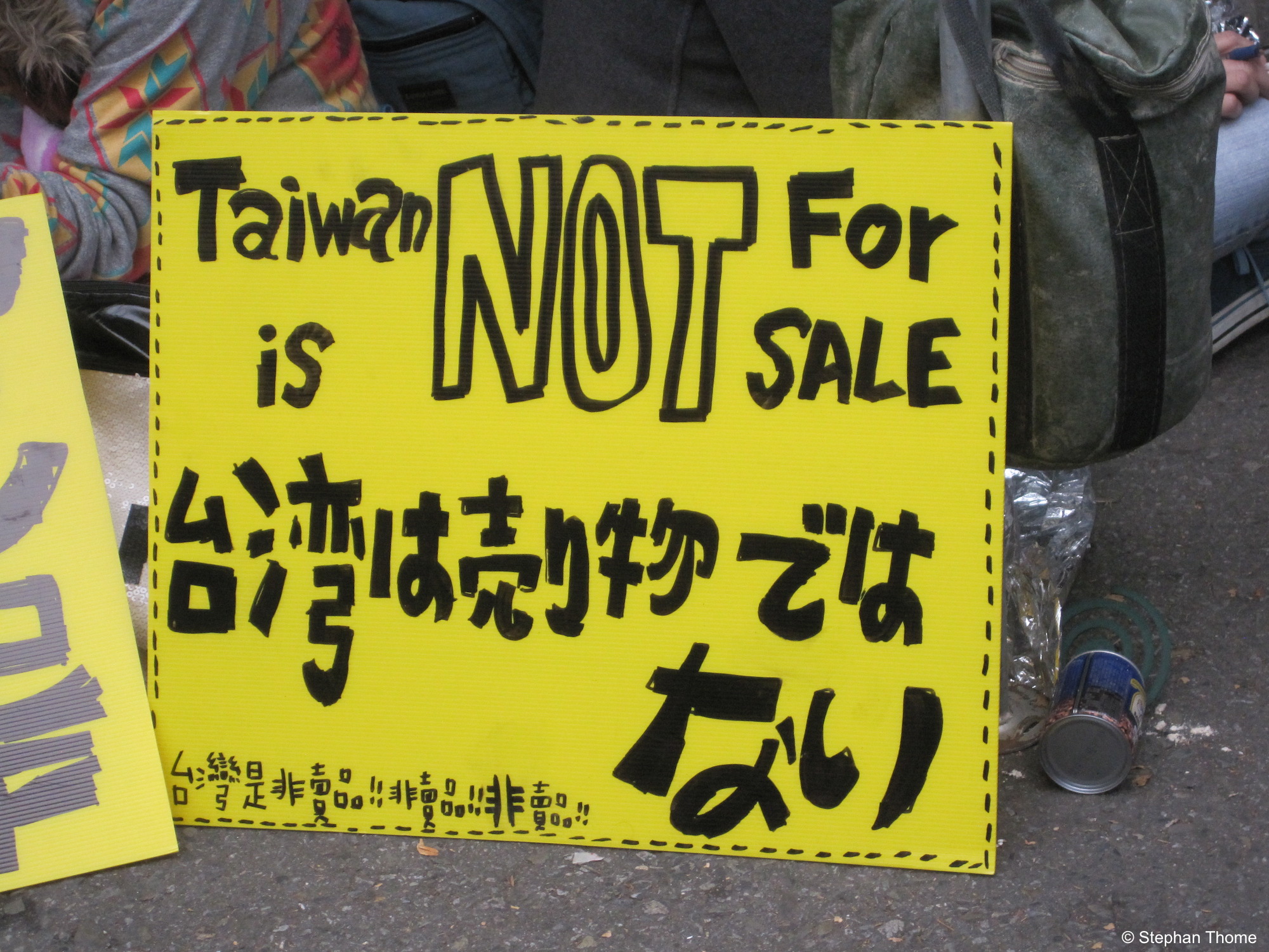Protest in drei Sprachen: Englisch, Japanisch, Chinesisch.