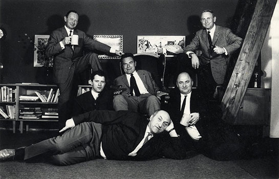 Paul Flora im Atelier (links) und 1966 inmitten der Karikaturisten Manfred Schmidt, Loriot, Reiner Zimnik, Ernst Hürlimann und E. M. Lang (beide © TLM)